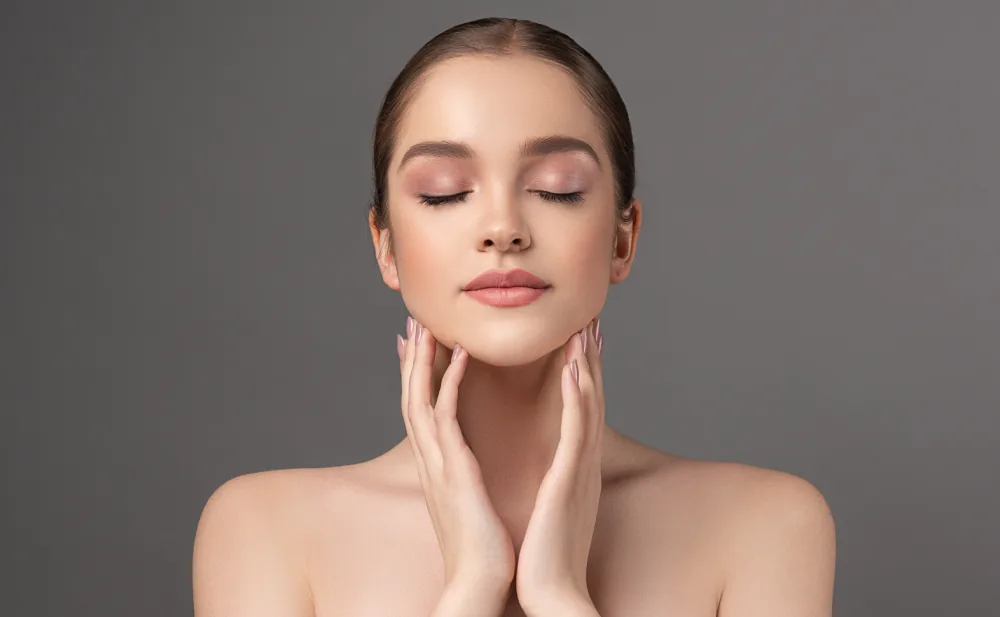 A woman with eyes closed touching both sides of her neck against dark grey