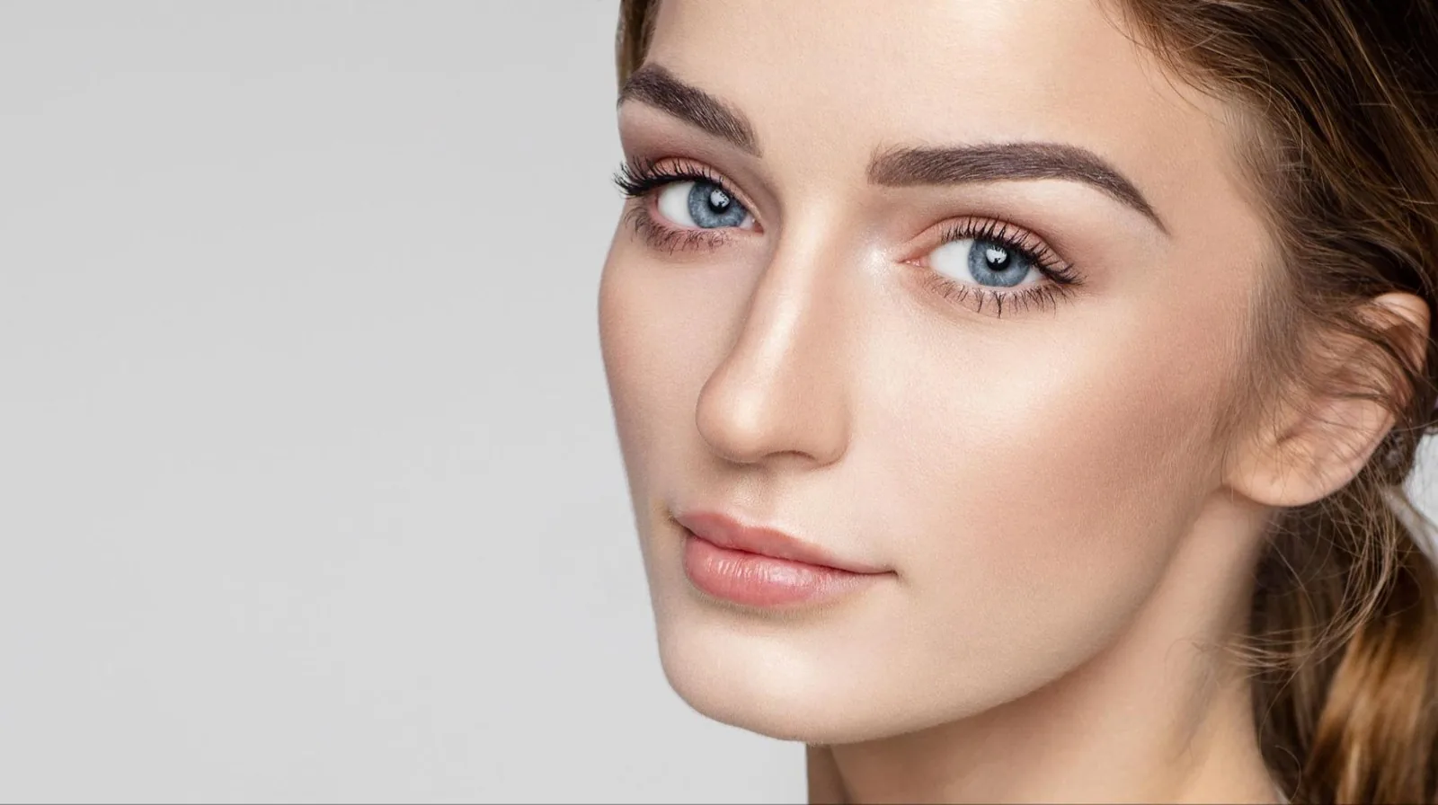 Close-up of a woman with blue eyes and clear skin looking at the camera
